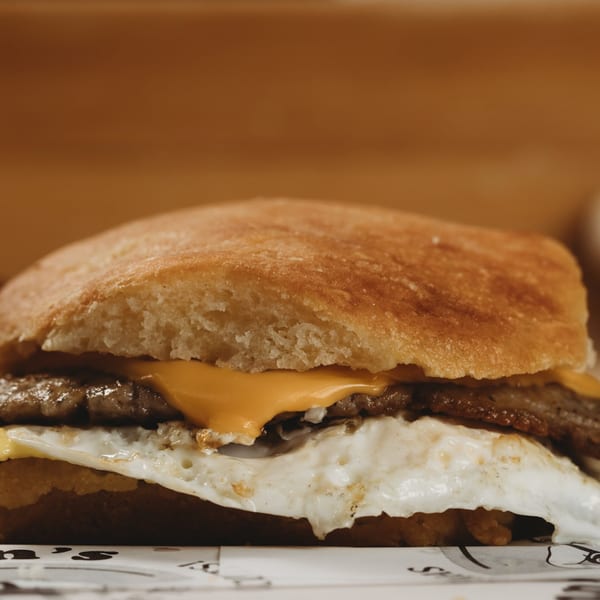 Close-up of Lou Ann's breakfast sandwich with egg, sausage, and cheese on a biscuit.