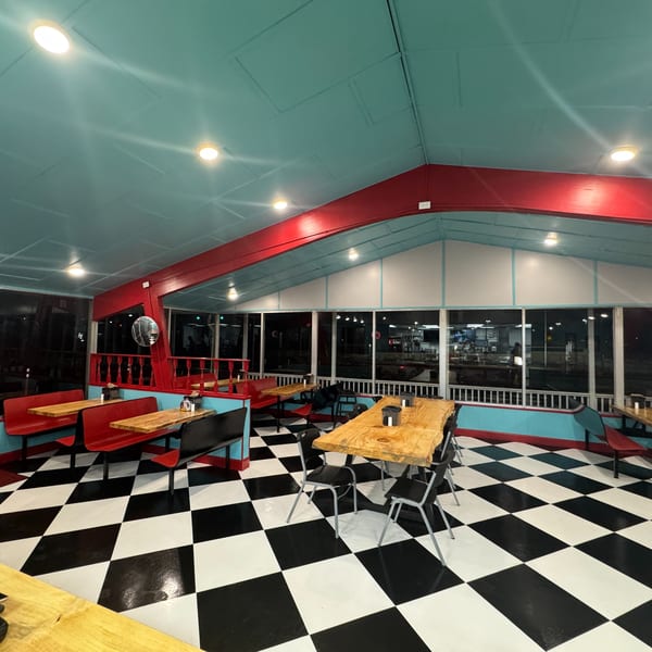 Lou Ann's Biscuits & Burgers interior with red booths, wooden tables, and a black and white checkered floor.